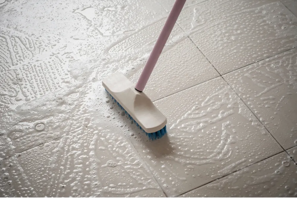 Brush scrubbing tile grout during a deep clean